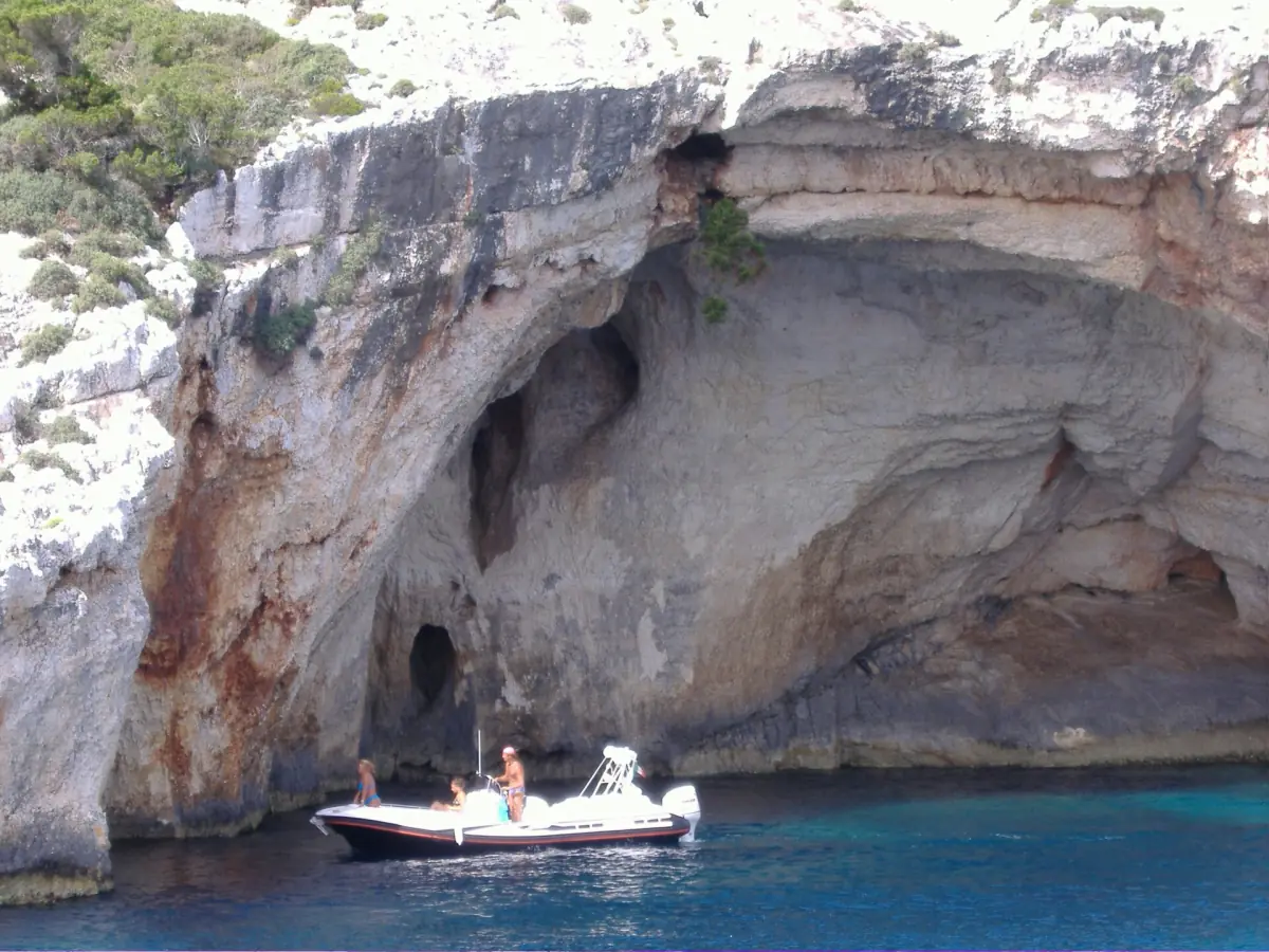 A small boat at the entrance of a sea cave